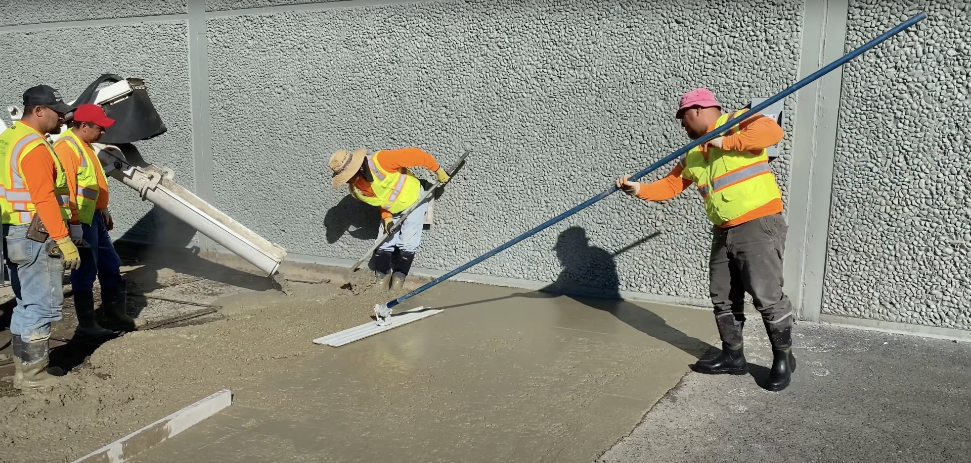 Professional concrete finishing work showing skilled craftsmen smoothing concrete surface